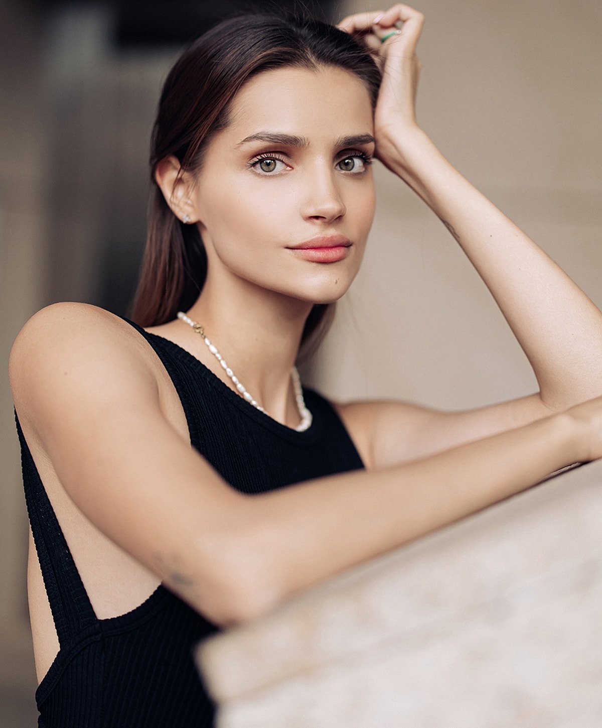 Woman posing with natural makeup and black dress.