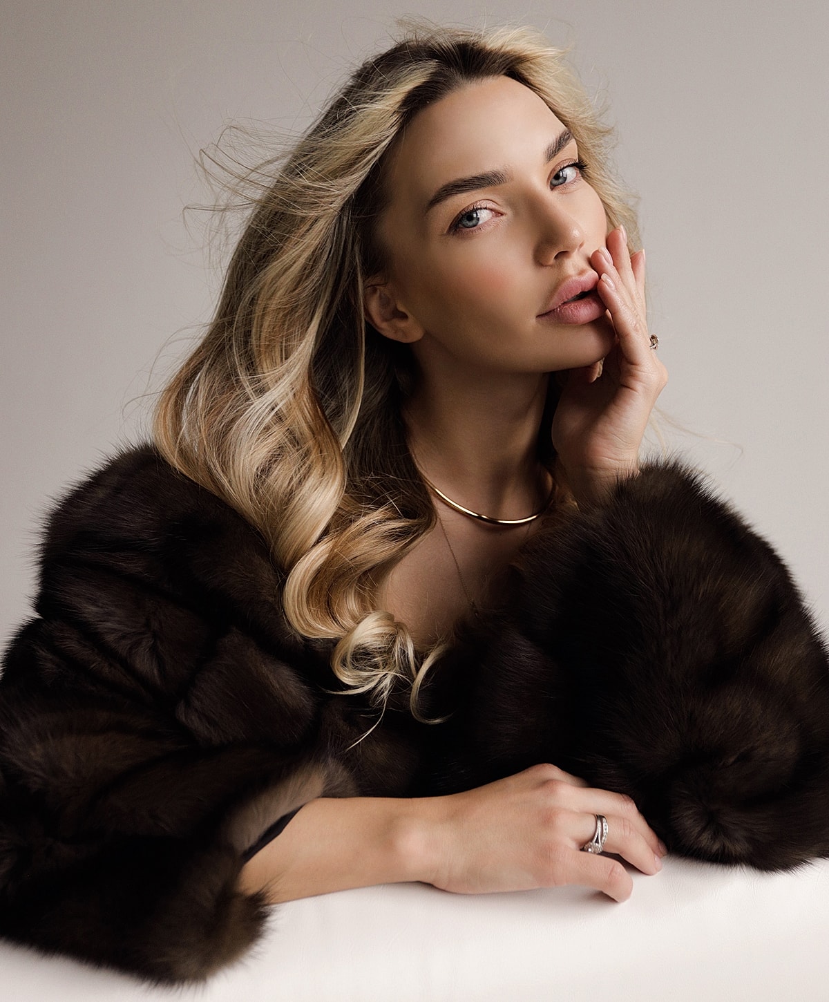 Woman with blonde hair in luxurious fur coat.