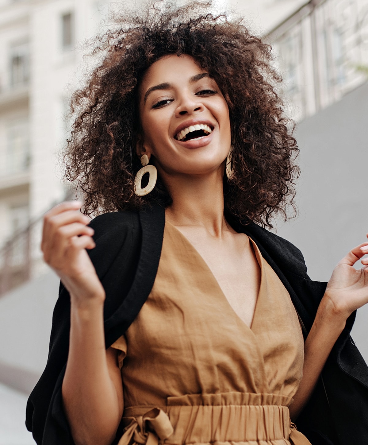 Smiling woman in stylish brown outfit outdoors.